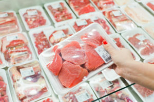 imballaggi offerte ingannevoli alimentare carne supermercato Packaged meat with woman hand in the supermarket