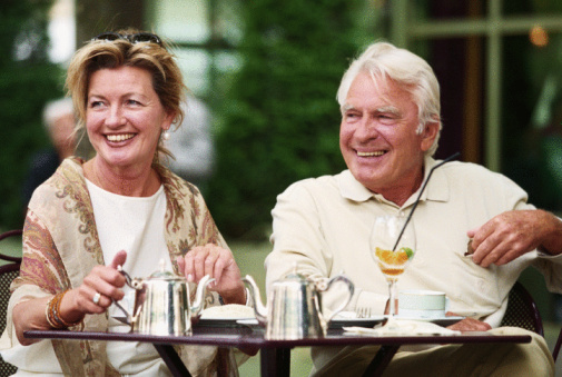 Mature couple sitting in street cafe