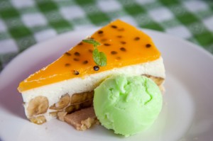 Cheese cake and ice-cream on plate with fruit topping.