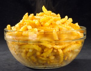 Glass bowl full of hot fries and rising steam.