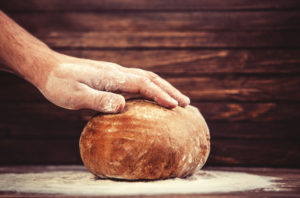 Baker's hands with a bread.