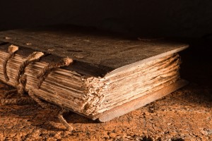 Medieval book of more than 300 years old with a wooden cover on a grungy table