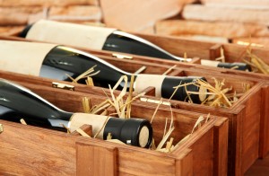 Bottles of old red wine in gift wooden box, on stone background