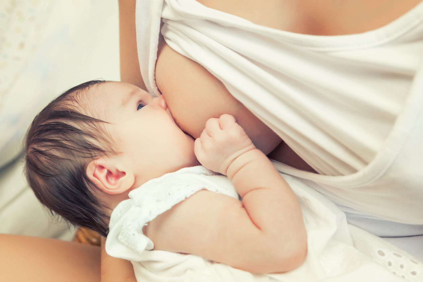 Soft focus image of newborn baby breastfeeding