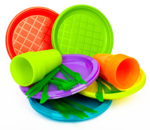 Disposable bright plastic kitchenware stacked on white